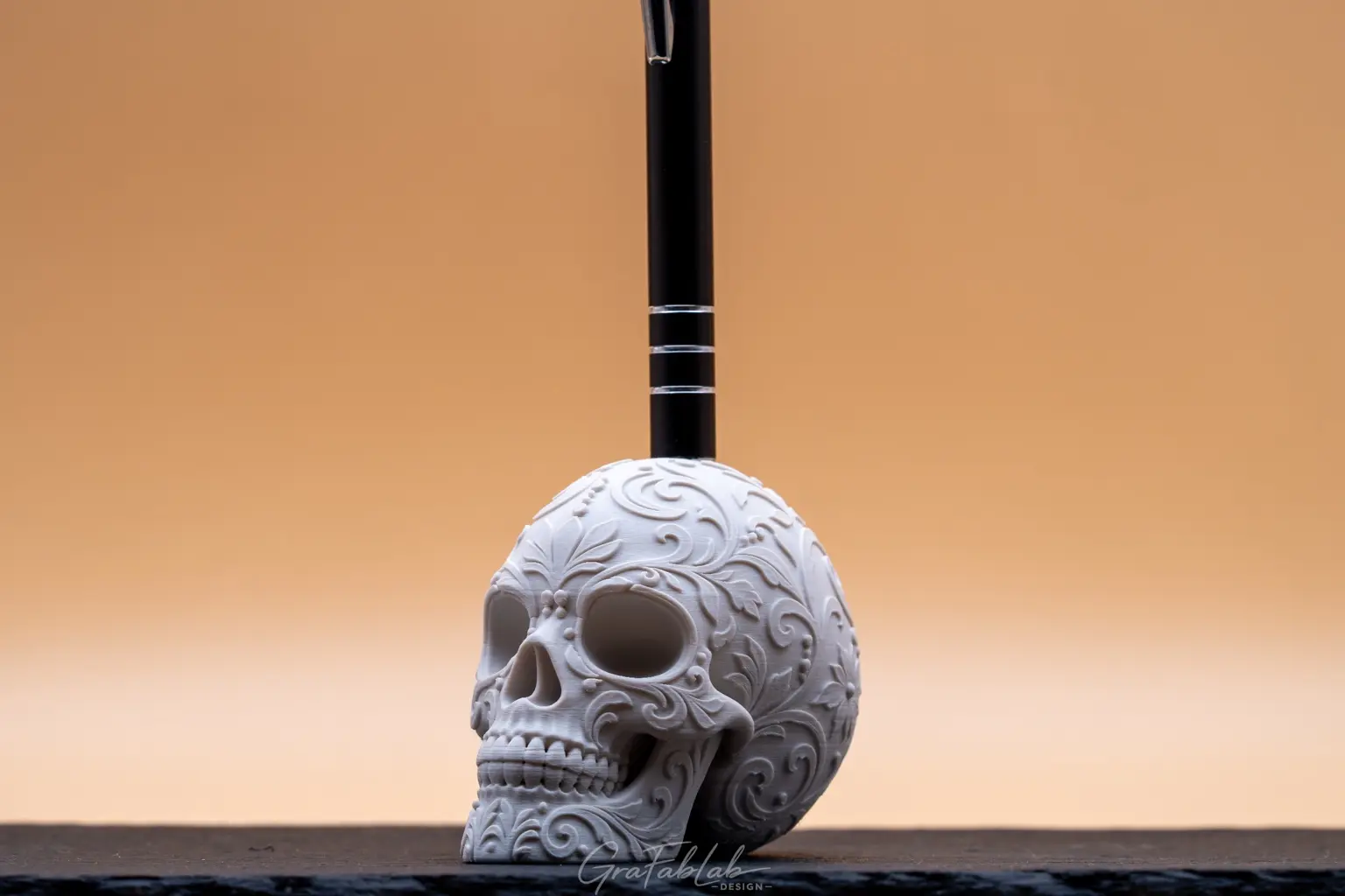 White ornamental skull prototype used as a pen holder